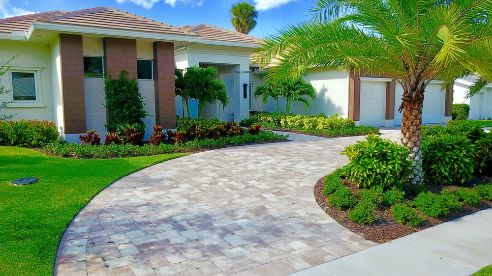 Curved paver driveway with tropical landscaping